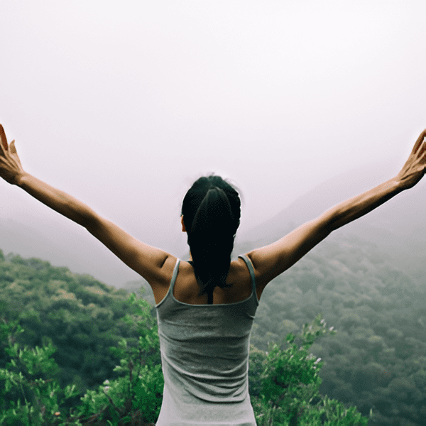 Person with arms raised in forest
